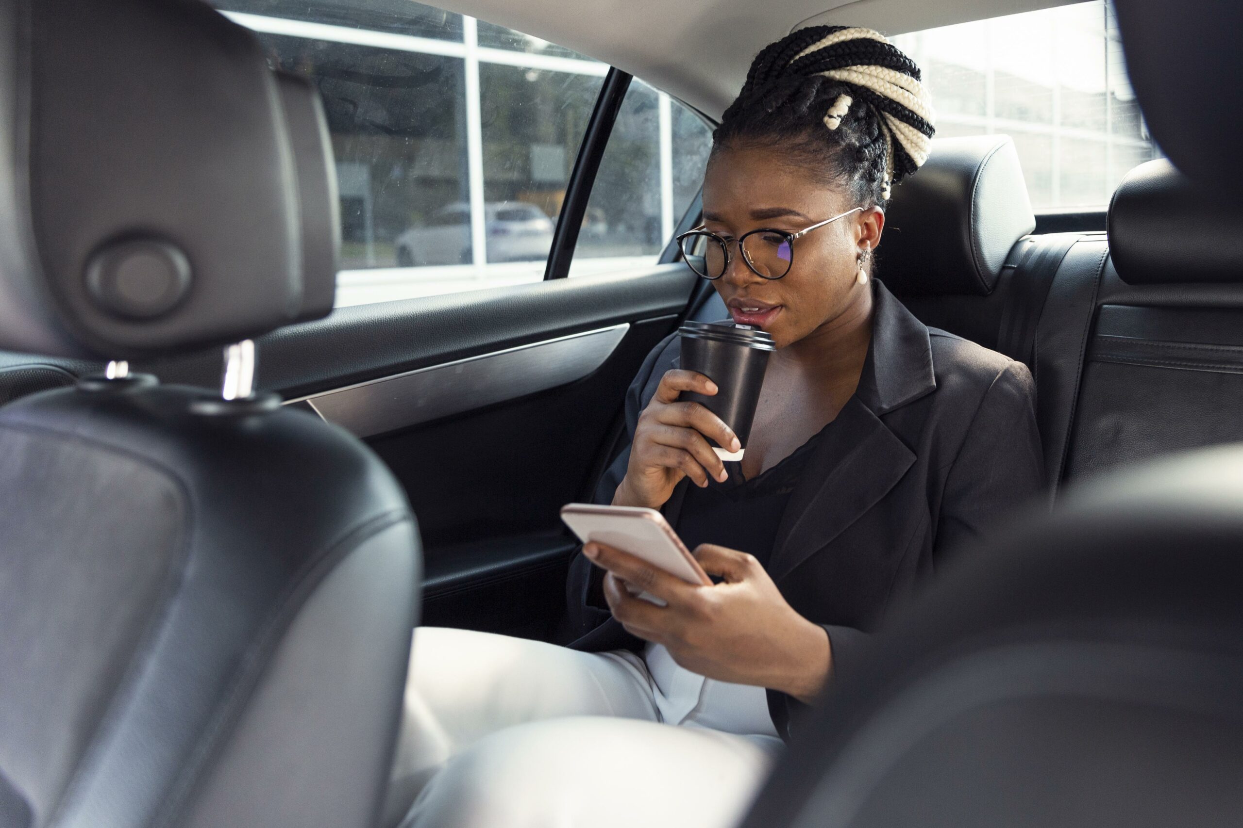 woman looking smartphone having coffee her car scaled